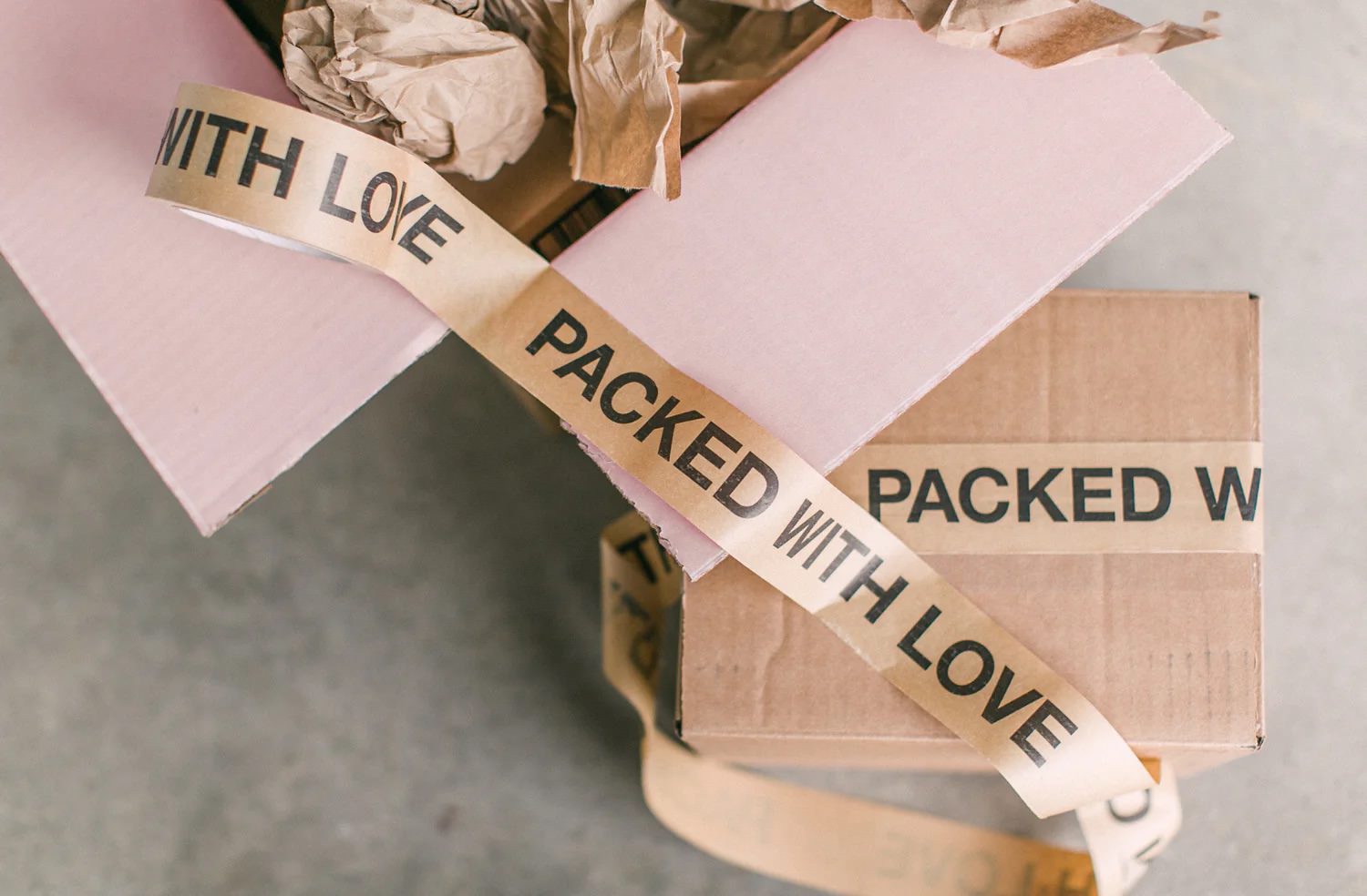 boxes with packing tape around then that say packed with love