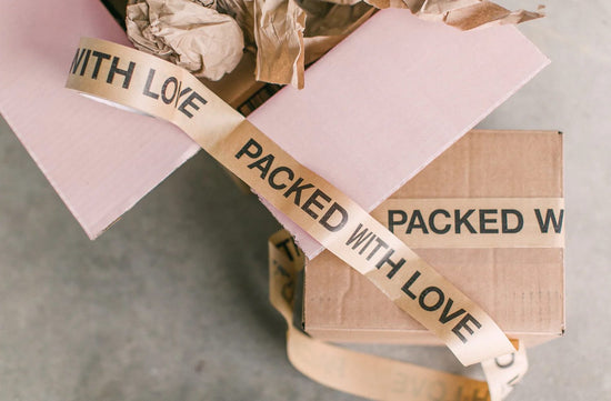 boxes with tape that says packed with love